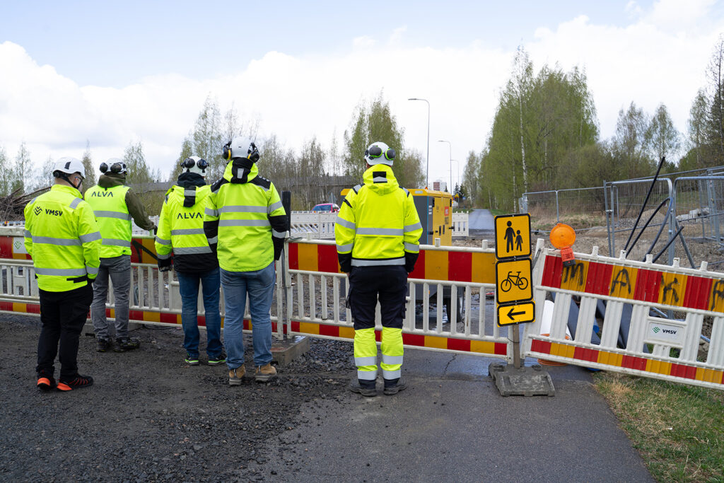 Alvan johto ja sopimusurakoitsijat turvallisuuskävelyllä työmaalla.